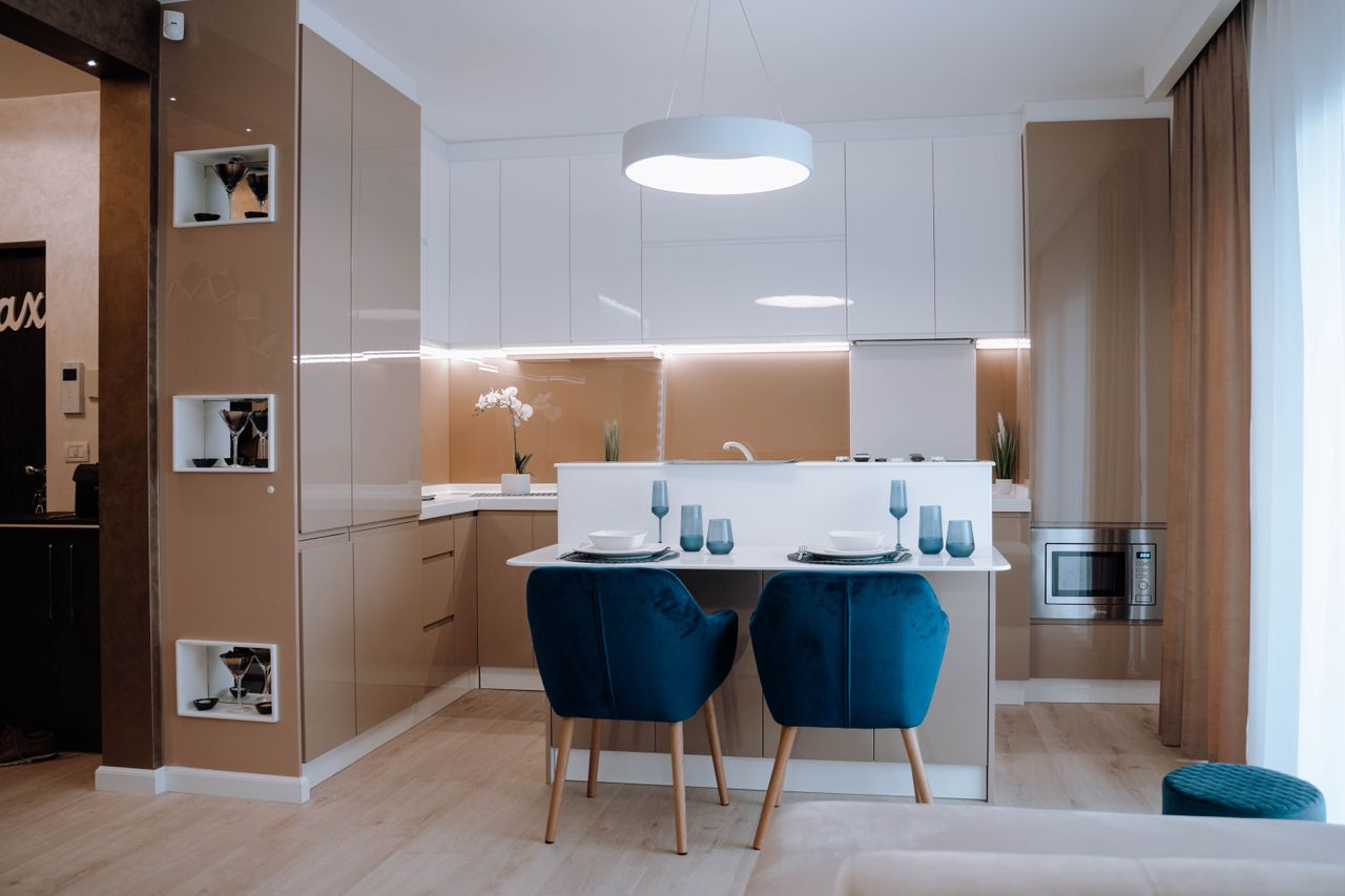 A stylish modern kitchen interior featuring sleek cabinetry and elegant dining setup.